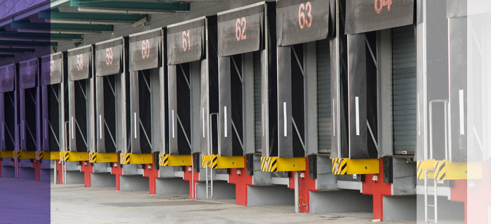 Photo of the back of a warehouse with many docks using protective dock seals.