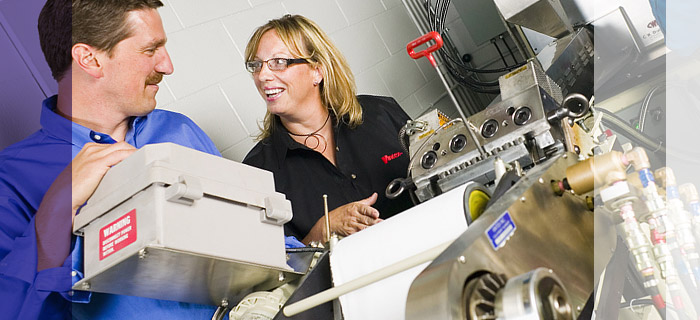 Photo of Vintex Senior VP of Operations and Product Development Technician discussing new products over our mini-extruder.