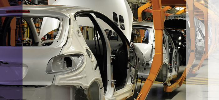 Photo of cars going through the assembly line at a car plant.